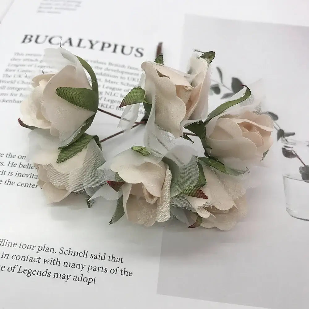 A delicate cluster of decorbites ivory flower cherry stamen cream fabric roses with green stems for wedding decor