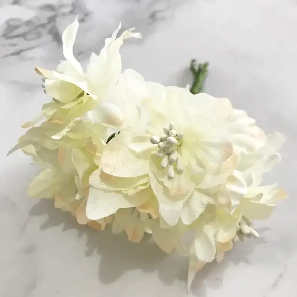 A delicate cluster of decorbites ivory flower cherry stamen berries with cream-colored layered petals for wedding decor