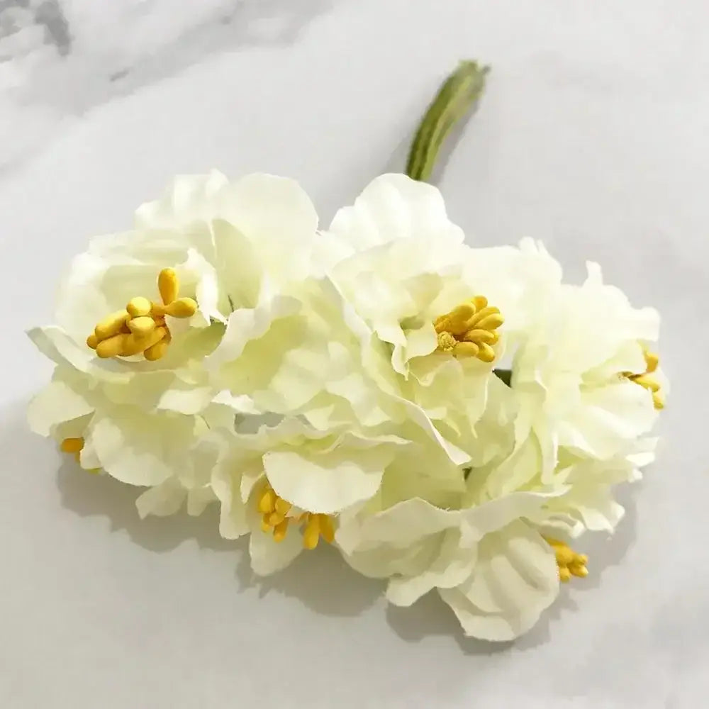 A cluster of decorbites ivory flower cherry stamen artificial white flowers with layered petals and yellow centers for wedding decor