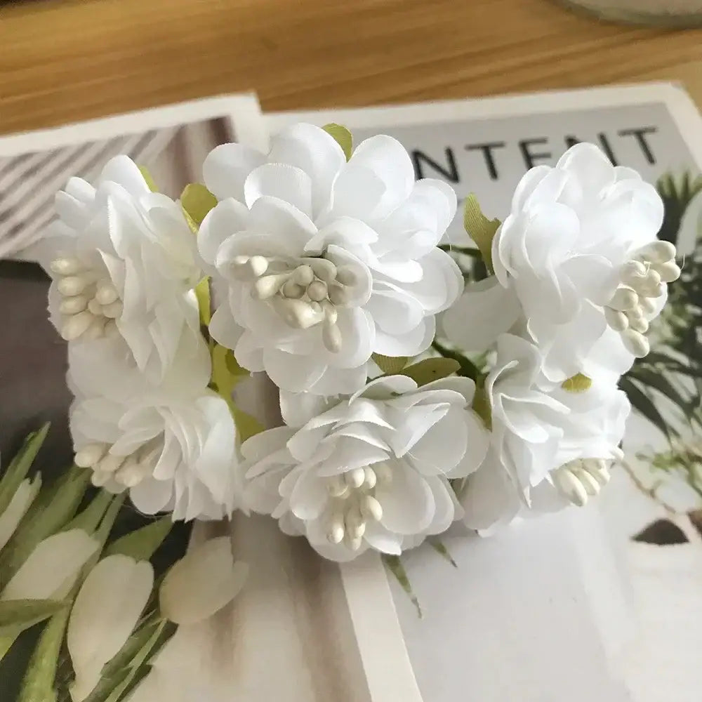 A cluster of decorbites ivory flower cherry stamen berries with delicate white petals and subtle green stems for wedding decor
