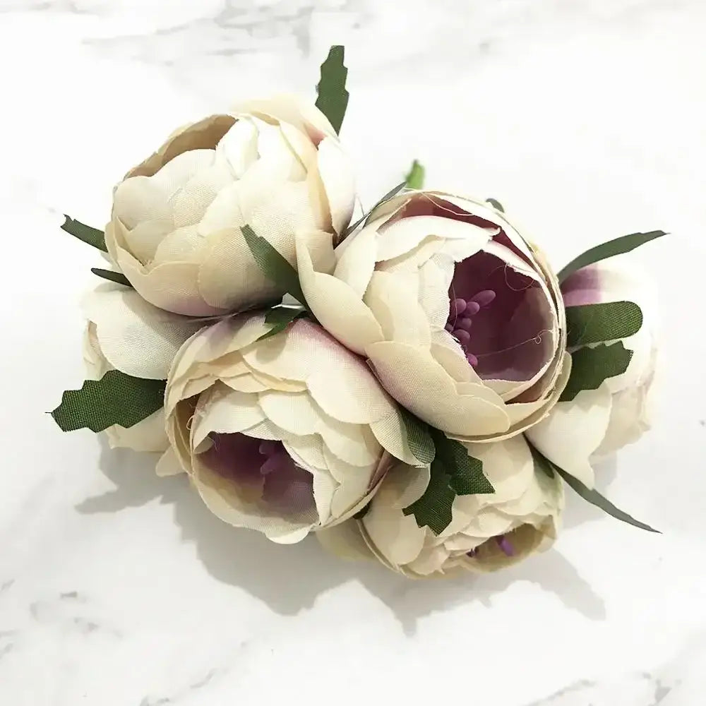 A delicate cluster of decorbites ivory flower cherry artificial peonies with purple centers and green leaves for wedding decor