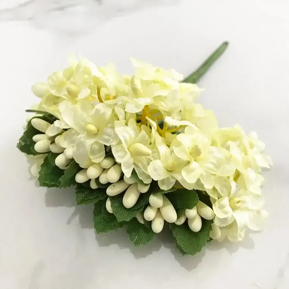 A delicate cluster of decorbites ivory flower cherry stamen berries with green fabric leaves for wedding decor