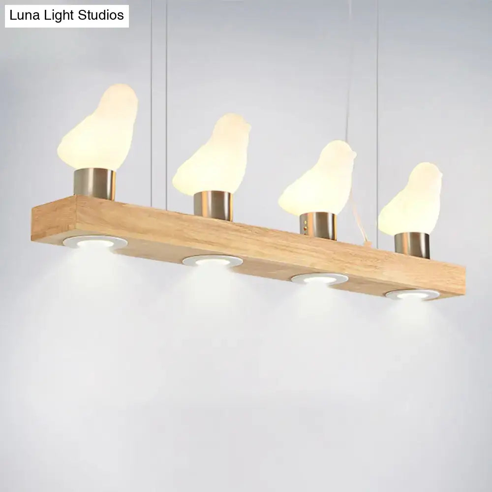 Modern wooden pendant light with four glowing ivory glass bird lamps and brushed metal bases from decorbites glass bird island collection
