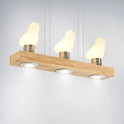 Decorbites ivory glass bird island pendant lighting fixture with three warm glowing bird island pendant lamps on wood plank