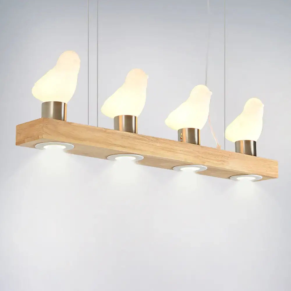 Modern wooden pendant light with four glowing ivory glass bird lamps and brushed brass bases from decorbites glass bird island collection