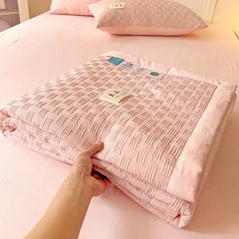 A soft pink decorbites jacquard summer cool blanket with quilted texture and neatly folded edges for bedroom use