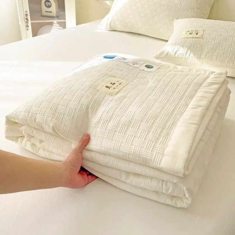 A neatly folded white decorbites jacquard summer cool blanket with subtle woven texture and soft plush appearance