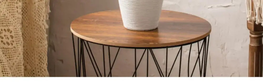 A round wooden table with a black metal wireframe base holding a white textured minimalist hydroponic vase from decorbites japanese minimalist hydroponic vase set