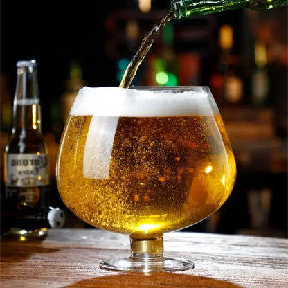 Golden beer with frothy white head poured into clear stemmed glass in decorbites jumbo party large capacity goblet