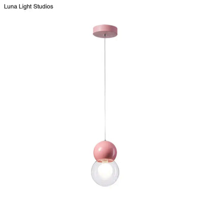 Pink kids bedside pendulum light featuring a spherical pendant with a clear glass globe and macaron ceiling pendant design