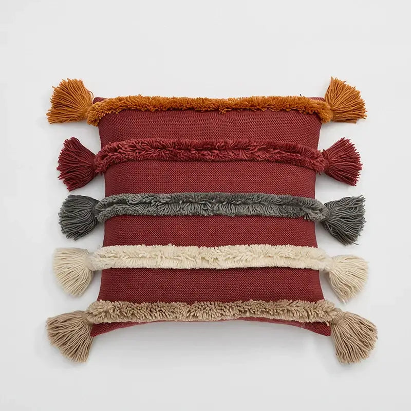 A rectangular rust-red decorbites knit boho cushion cover with earthy fringe bands and tassels for living room decor