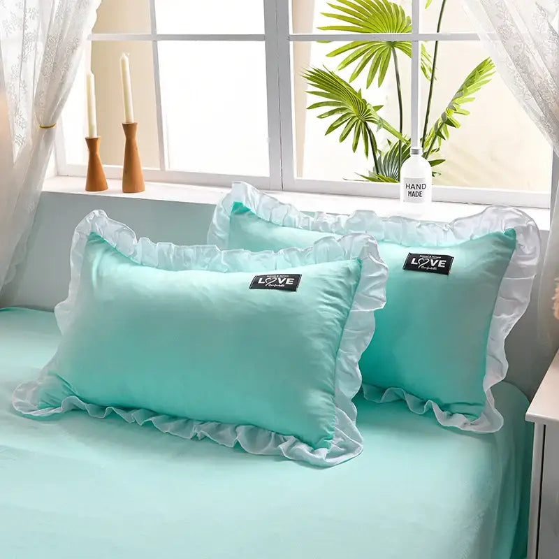 Pair of mint green satin pillowcases with delicate white princess ruffles and love patches from korean princess ruffles quilt set
