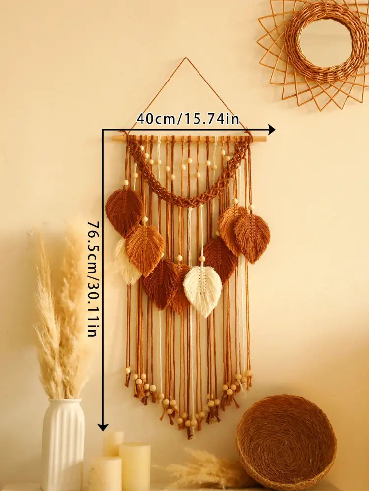 A decorbites™ macrame wall hanging with woven leaf accents in brown and cream tones on a wooden dowel