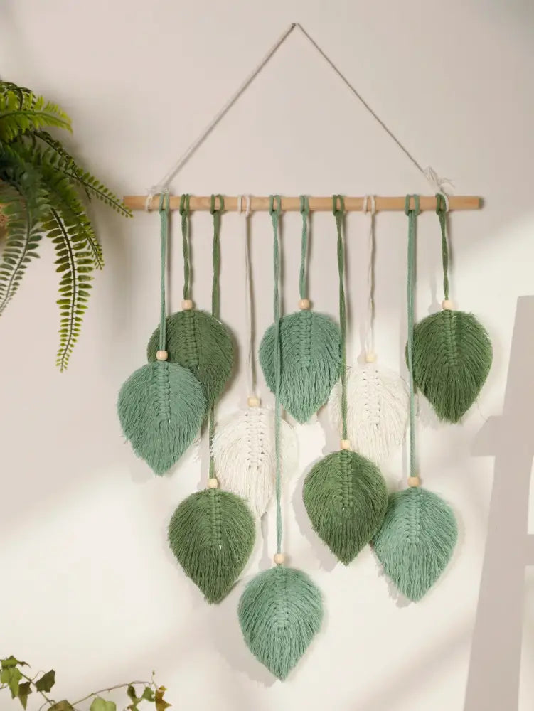 DecorBites™ macrame wall hanging with green and white woven leaves on brown wooden rod for boho home decor