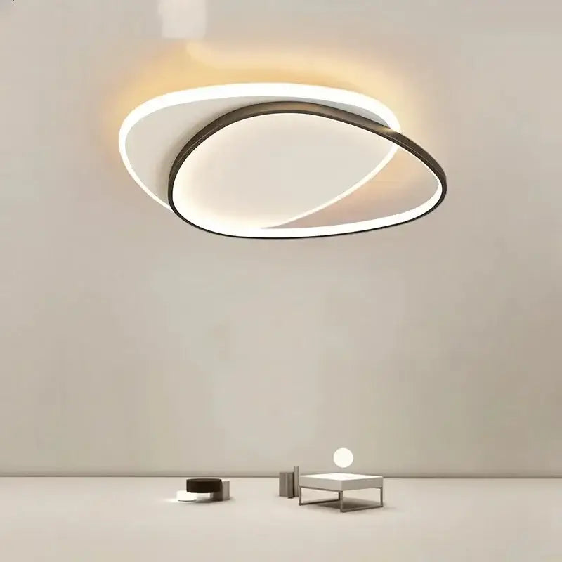 Modern minimalist decorbites led ceiling light with interlocking white and dark metallic oval rings emitting warm glow