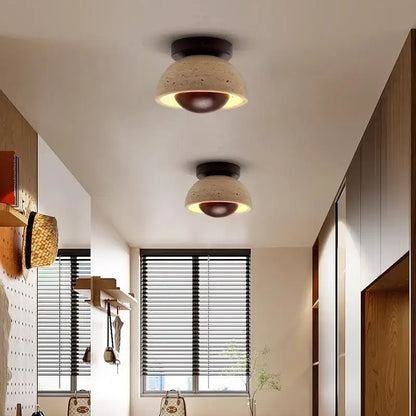 Two modern style decorbites led ceiling lights with beige concrete shades and dark brown bases emitting warm glow
