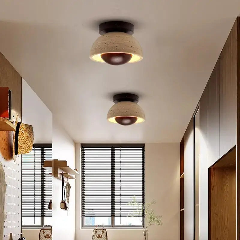 Two modern style decorbites led ceiling lights with beige concrete shades and dark brown bases emitting warm glow