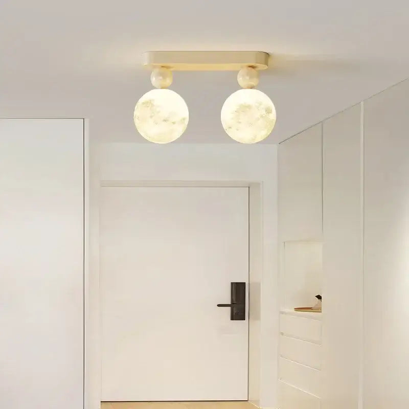Modern decorbites led ceiling fixture with two illuminated moon globes and cream rectangular bar for minimalist lighting