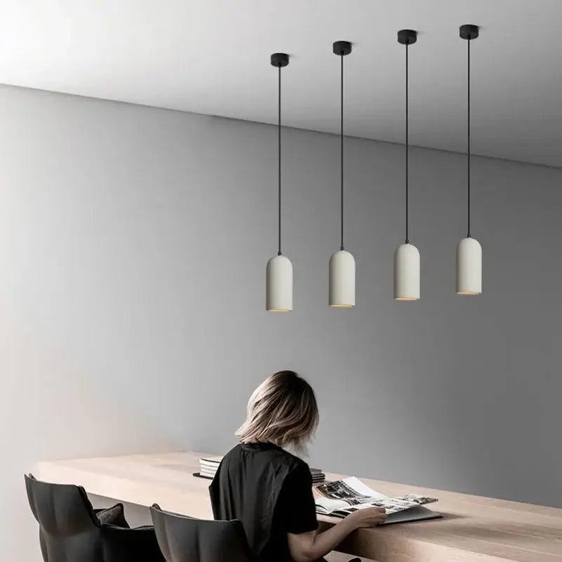 Four minimalist pendant lights with matte off-white shades and black cords in decorbites led cement chandelier for bedroom