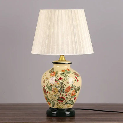 Cream-colored decorbites led ceramic table lamp with intricate floral design and pleated off-white fabric shade for home decor lighting