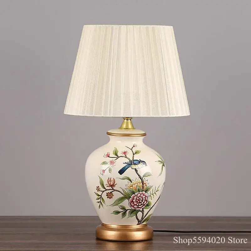 Cream-colored decorbites led ceramic table lamp with hand-painted blue bird floral design and gold-toned metal base