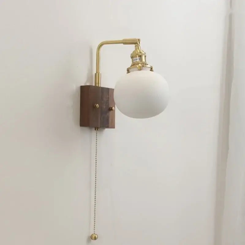 DecorBites led ceramic wall sconce with brass finish, dark wood base, and opaque white glass shade light fixture