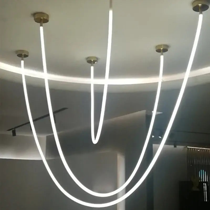 Modern minimalist pendant light with five glowing white led strips and brass-finished mounts by DecorBites LED chandelier
