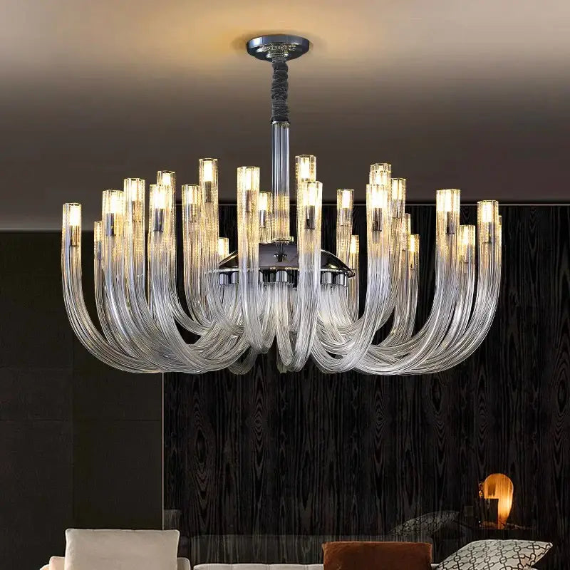 A modern decorbites led chandelier with curved transparent glass arms and a chrome lighting fixture for bedroom use