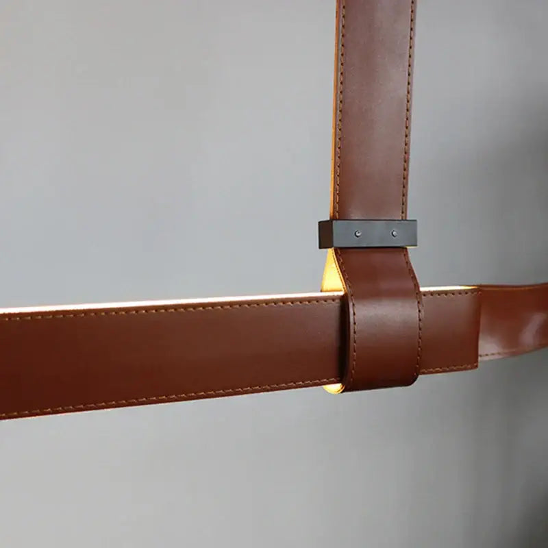 Brown leather strap with black metal clasp detail of decorbites led chandelier for dining room and kitchen use