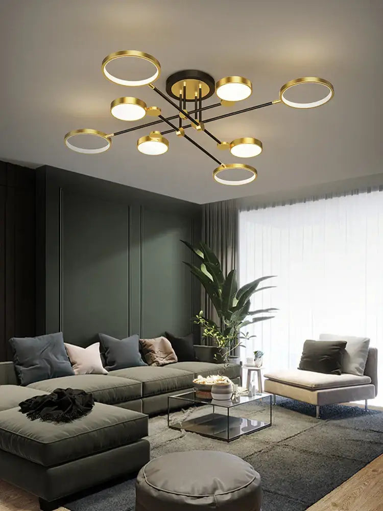 Modern gold-toned DecorBites LED chandelier with circular light fixtures and black metal arms for living room lighting