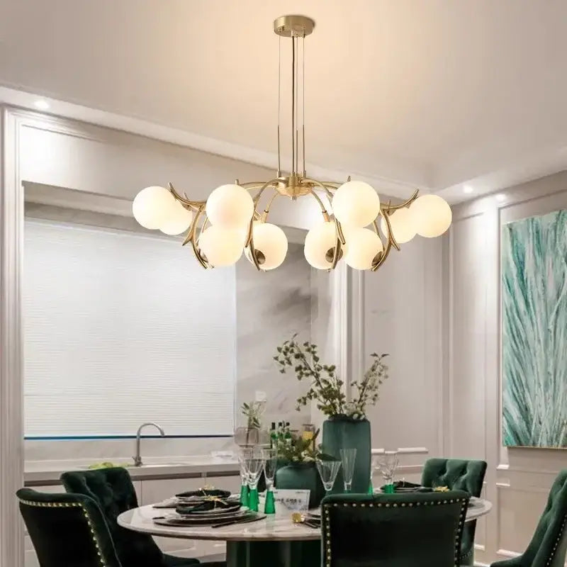 Gold-toned DecorBites LED chandelier lighting with frosted glass globes in a branching design for living room décor