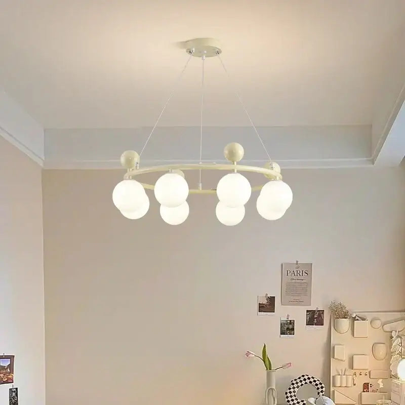 Off-white circular DecorBites led chandelier with multiple frosted glass globe bulbs suspended by thin cords for indoor lighting