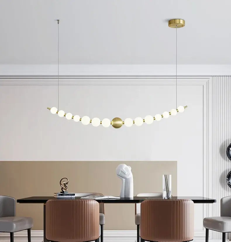 Gold-toned decorbites led chandelier necklace lighting with spherical glass bulbs in an elegant curved line for dining room