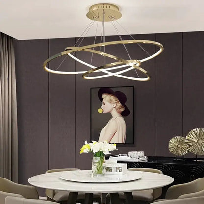 Modern gold-toned decorbites led chandelier pendant with circular intersecting rings above dining table lighting