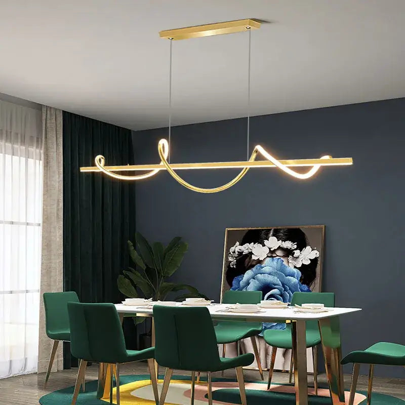 Gold-colored DecorBites LED chandelier pendant with sleek curved design hanging above a dining table for modern lighting