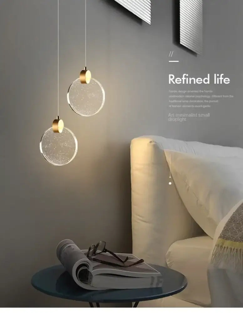 Two decorbites™ led crystal pendant lights with clear glass shades and gold fixtures for bedroom and bathroom use