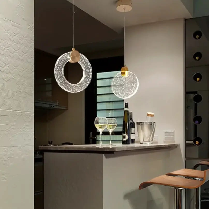 Two modern circular led crystal pendant lights with sparkling glass and gold accents for bedroom and bathroom use