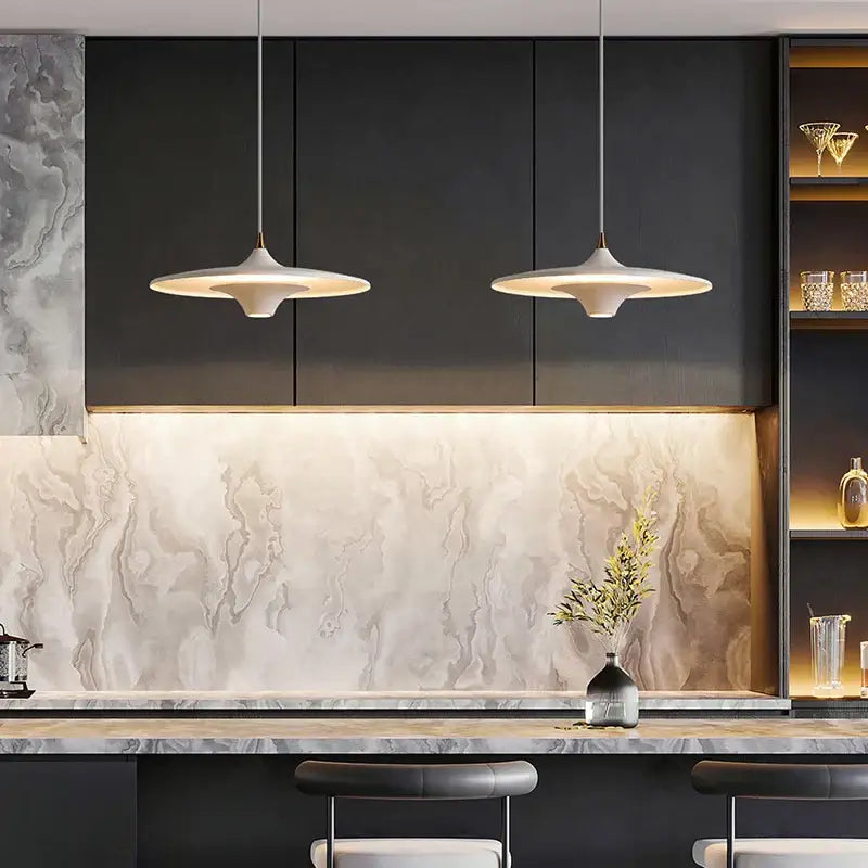 Two off-white DecorBites LED flying saucer pendant lights with modern disc design hang above kitchen counter