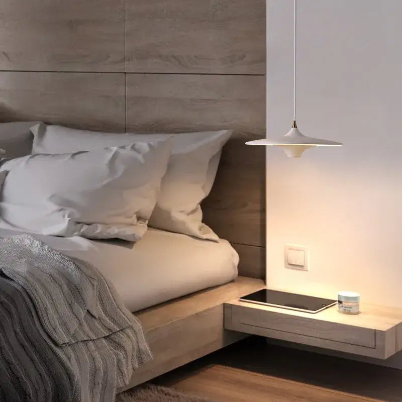 Modern white decorbites led flying saucer pendant lights with minimalist design hanging above a floating nightstand