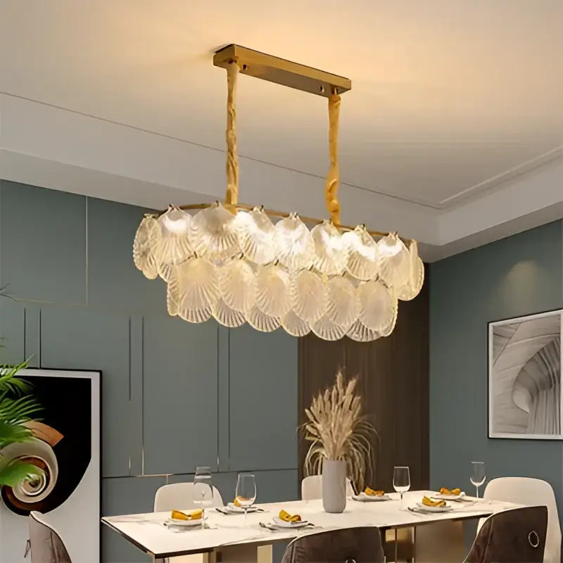 Gold-toned decorbites led frost glass shell chandelier with rectangular frame and cascading translucent frost glass elements