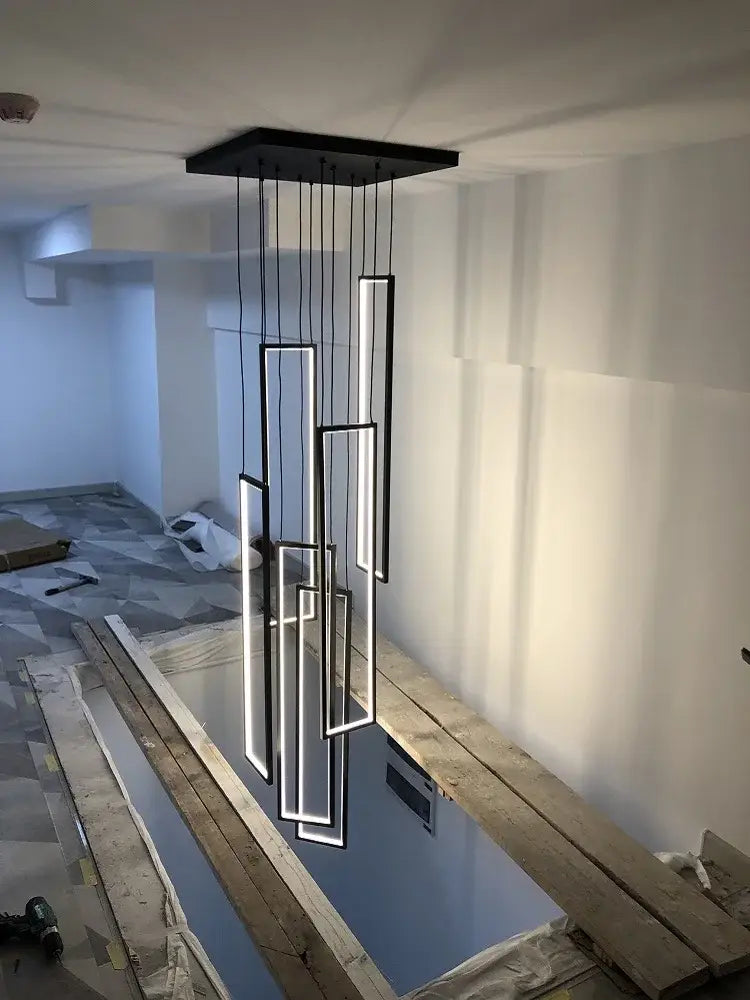 Modern black rectangular DecorBites led geometry stair chandelier with glowing white panels suspended from ceiling mount