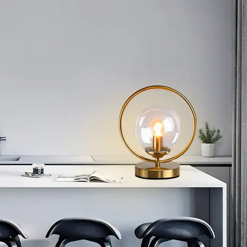 A modern decorbites led glass brass ring table lamp with clear globe and exposed filament bulb for stylish lighting