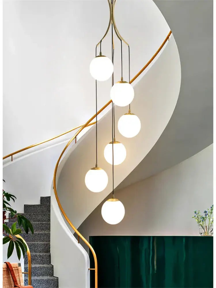 A modern brass decorbites led glass ball chandelier with five white glass globes for living room ceiling light