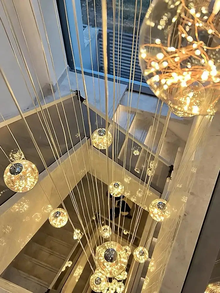 A decorbites led glass ball chandelier with warm glowing spherical orbs suspended by thin metallic wires for duplex villa