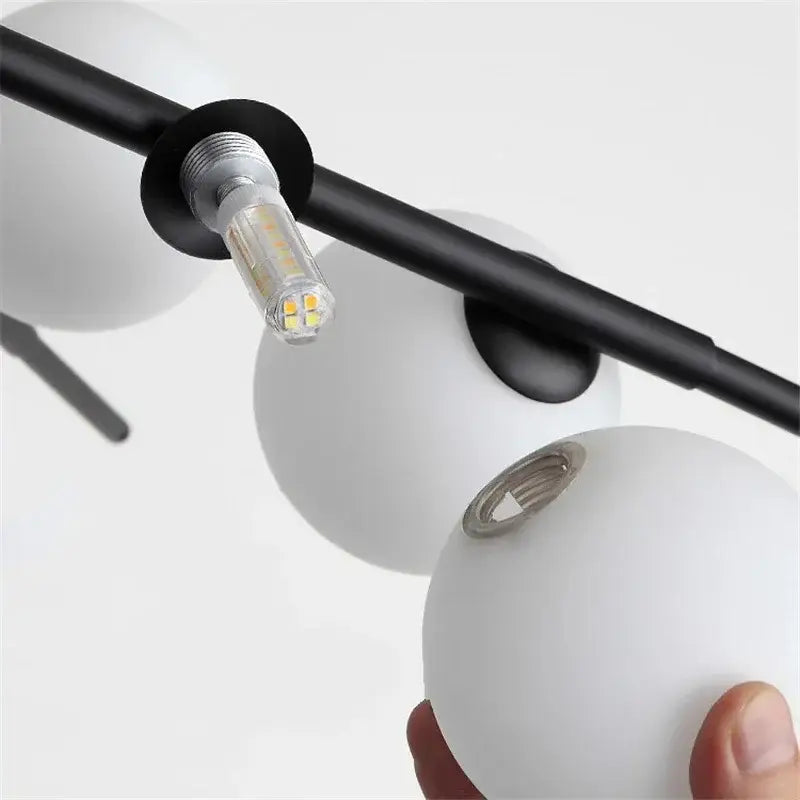 White frosted glass globe pendant light with black metal arm and led bulb from DecorBites led glass ball series