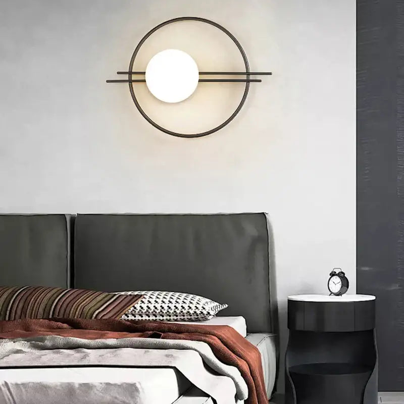 Modern black metal wall sconce with circular frame and glass ball light bulb by DecorBites LED for bedroom living room