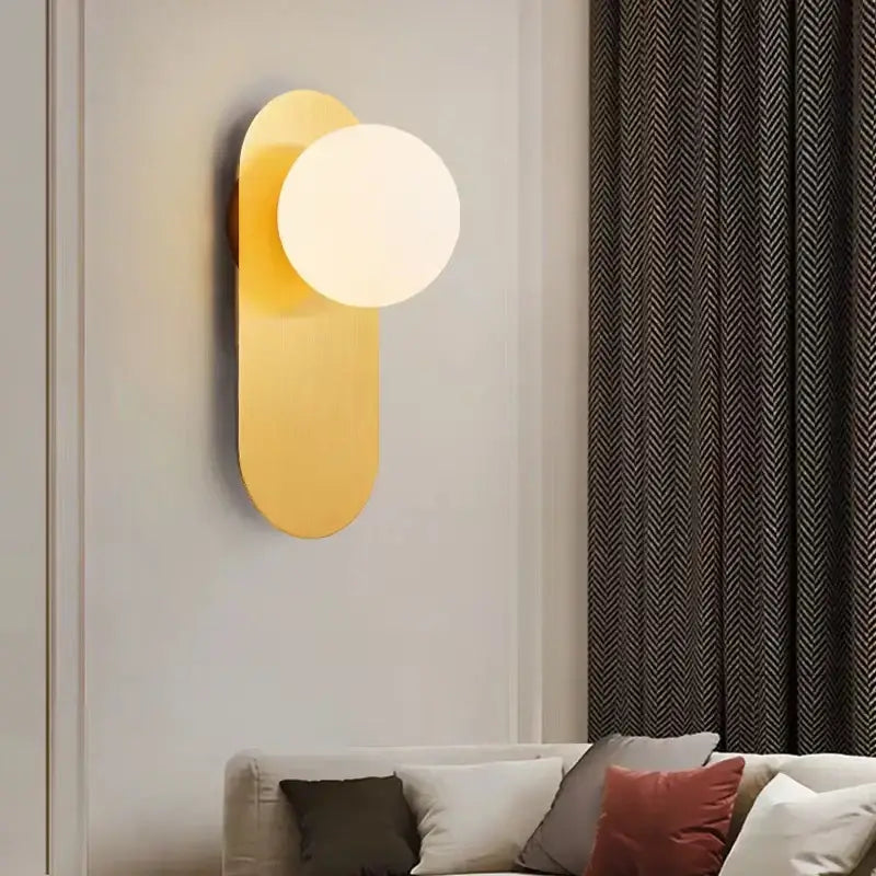 Gold-toned decorbites led glass ball wall sconce with sleek oval base and frosted glass bulb for bedroom or living room