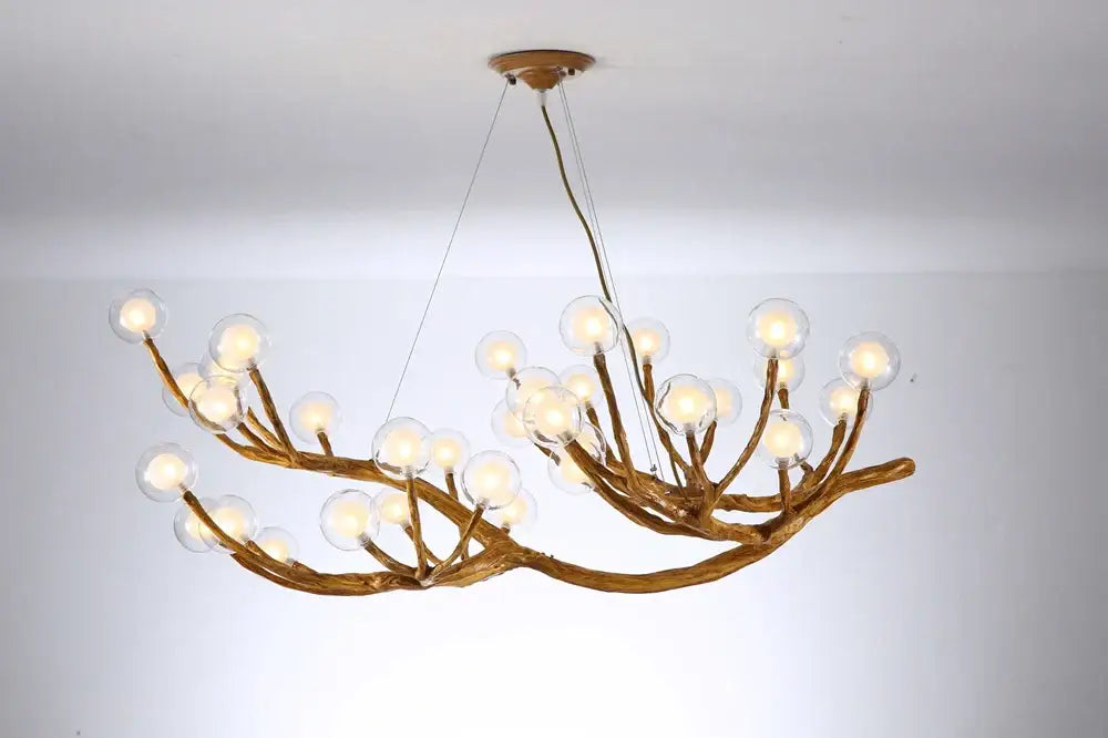 A rustic gold-toned decorbites led glass bubble chandelier with branching arms and clear glass globe bulbs for loft lighting