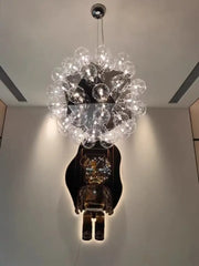 A decorbites led glass bubble chandelier with clear glass bulbs in a chrome finish above a dark bear sculpture