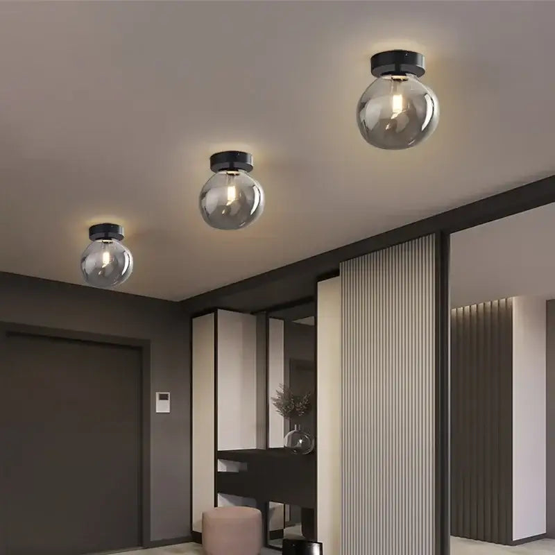 Three modern spherical decorbites led glass ceiling chandeliers with black fixtures for indoor home lighting